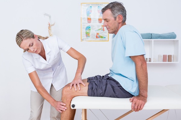 Ортопед проводит осмотр коленного сустава